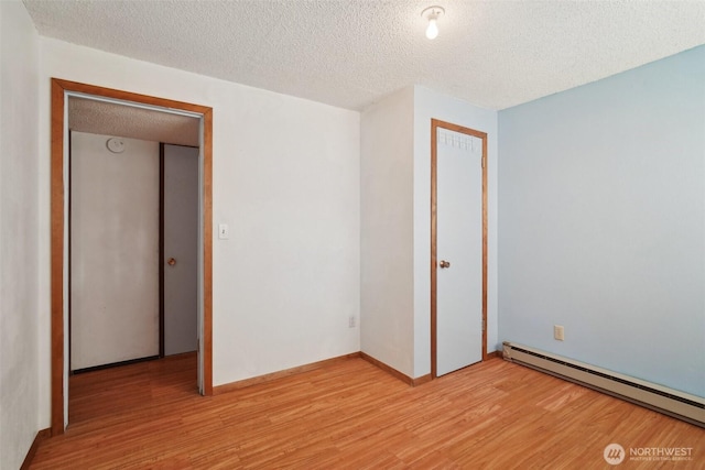 32427 6th Ave, Black Diamond, WA 98010 - spare room featuring a baseboard heating unit, a textured ceiling, and light wood-type flooring
