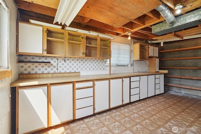 32427 6th Ave, Black Diamond, WA 98010 - kitchen with open shelves, light flooring, light countertops, wallpapered walls, and white cabinets