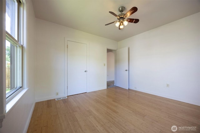 1030 N Clinton St, Walla Walla, WA 99362 - unfurnished bedroom featuring light wood-style floors, baseboards, ceiling fan, and arched walkways