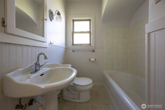 1030 N Clinton St, Walla Walla, WA 99362 - full bathroom featuring tile patterned flooring, toilet, a wainscoted wall, a tub to relax in, and a sink