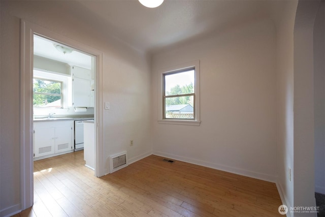 1030 N Clinton St, Walla Walla, WA 99362 - spare room with light wood-style flooring, arched walkways, a sink, and baseboards