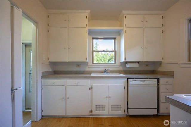 1030 N Clinton St, Walla Walla, WA 99362 - kitchen with dishwasher, a sink, light wood-style flooring, and white cabinets