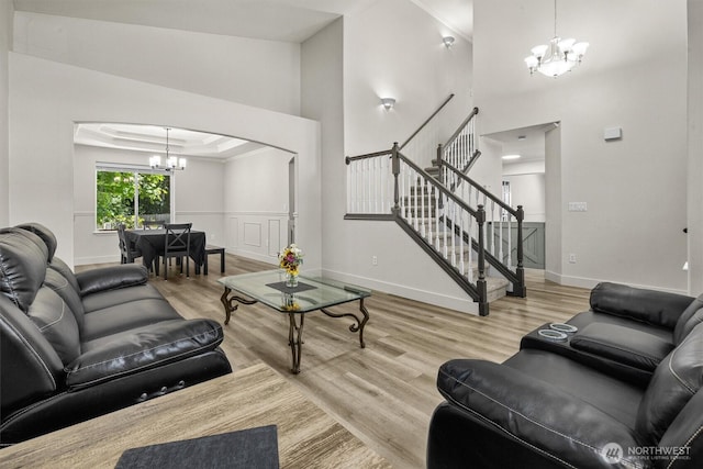 13901 Cedar Ct, Sultan, WA 98294 - living area with a chandelier, wood finished floors, a towering ceiling, stairs, and baseboards