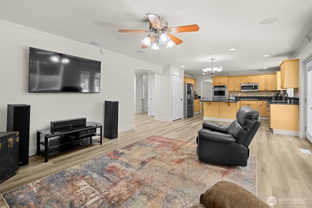 13901 Cedar Ct, Sultan, WA 98294 - living room featuring a ceiling fan, light wood-style floors, arched walkways, crown molding, and a chandelier