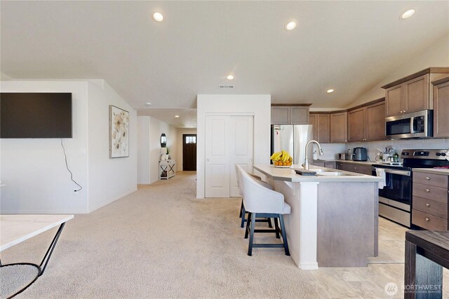 7 Patty Cir, Milton-Freewater, OR 97862 - kitchen featuring appliances with stainless steel finishes, recessed lighting, light countertops, a breakfast bar, and a kitchen island with sink