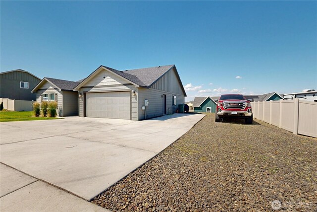 7 Patty Cir, Milton-Freewater, OR 97862 - view of side of home with concrete driveway, an attached garage, a shingled roof, and board and batten siding