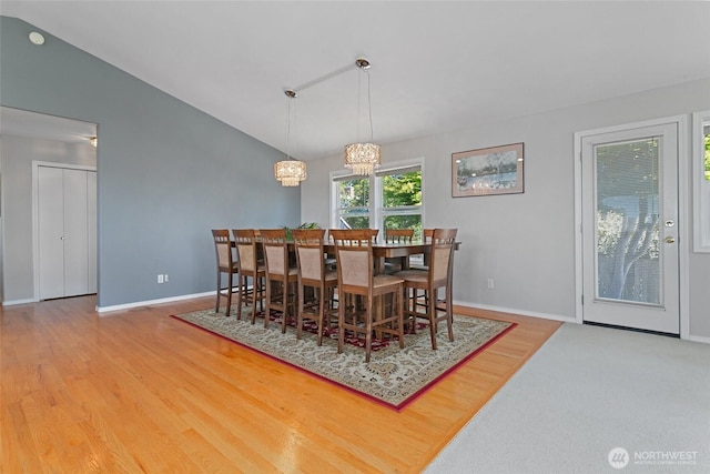 1022 S 225th Ln, Des Moines, WA 98198 - dining space with a chandelier, vaulted ceiling, and wood finished floors