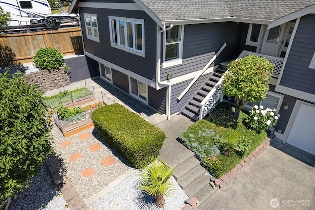 1022 S 225th Ln, Des Moines, WA 98198 - view of property exterior featuring a shingled roof, a garden, and stairs