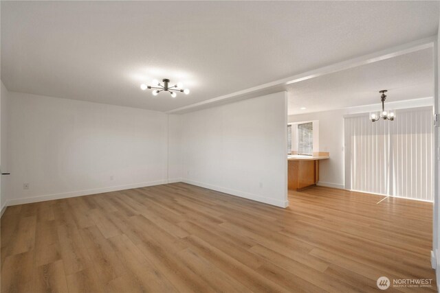 5201 S M St, Tacoma, WA 98408 - empty room with a chandelier, light wood-type flooring, and baseboards