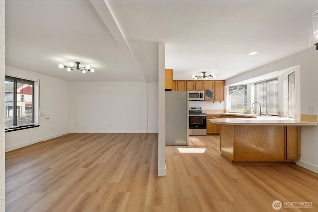 5201 S M St, Tacoma, WA 98408 - kitchen with stainless steel appliances, a chandelier, light wood-style floors, light countertops, and open floor plan