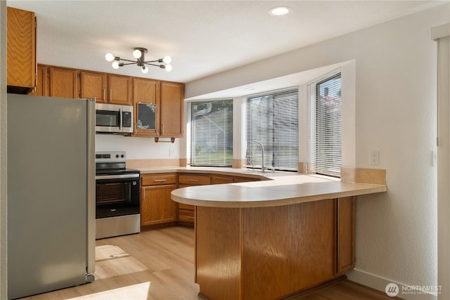 5201 S M St, Tacoma, WA 98408 - kitchen with appliances with stainless steel finishes, a peninsula, plenty of natural light, light wood finished floors, and recessed lighting