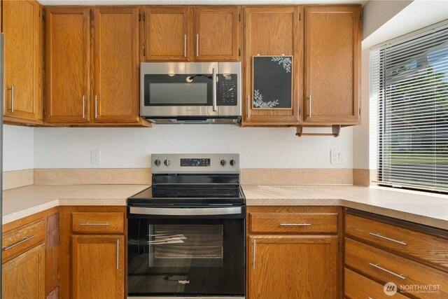 5201 S M St, Tacoma, WA 98408 - kitchen with appliances with stainless steel finishes, light countertops, and brown cabinetry