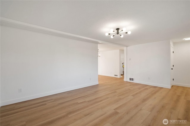 5201 S M St, Tacoma, WA 98408 - unfurnished living room featuring a chandelier, baseboards, and light wood-type flooring