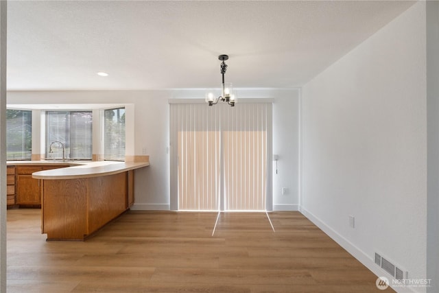 5201 S M St, Tacoma, WA 98408 - unfurnished dining area with a chandelier, light wood-style floors, baseboards, a sink, and recessed lighting