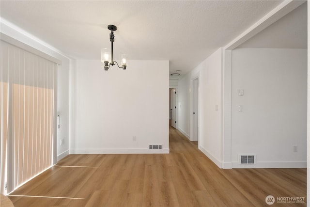 5201 S M St, Tacoma, WA 98408 - unfurnished dining area featuring light wood finished floors, a chandelier, and baseboards