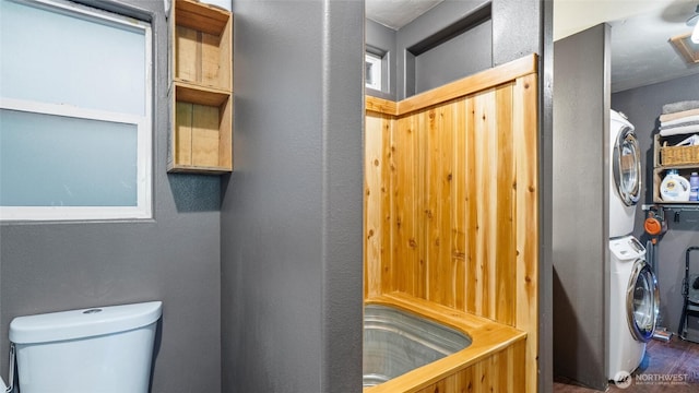 136 Tamarack Ln, Dayton, WA 99328 - bathroom with stacked washer / dryer, toilet, a textured wall, and wood finished floors