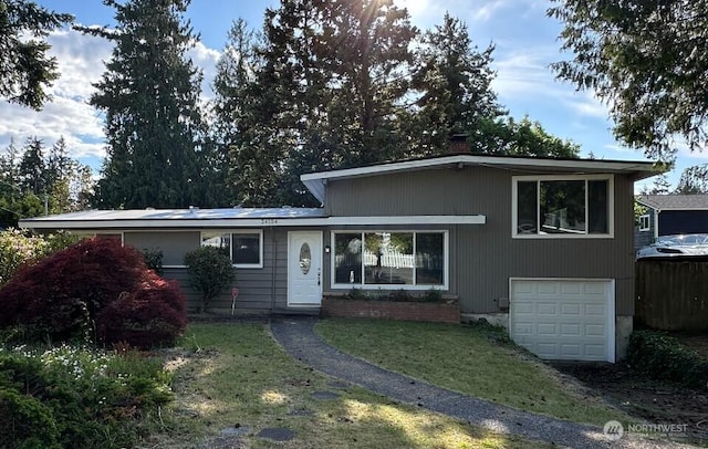 24104 105th Pl W, Edmonds, WA 98020 - tri-level home with an attached garage, a chimney, a front yard, and driveway