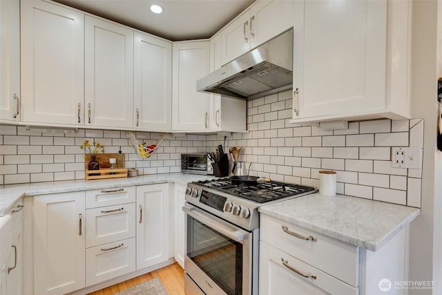 9741 Densmore Ave N, Seattle, WA 98103 - kitchen featuring gas stove, under cabinet range hood, and white cabinetry
