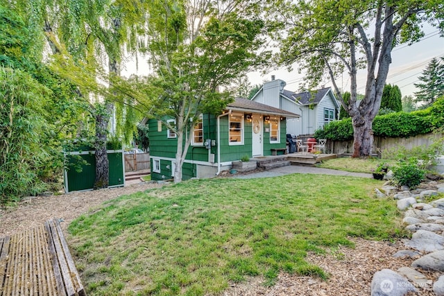 9741 Densmore Ave N, Seattle, WA 98103 - view of front of home with a fenced backyard, a chimney, a porch, and a shingled roof