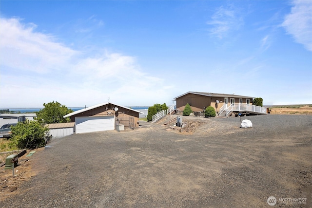 7220 E Belmont St, Othello, WA 99344 - view of front facade featuring stairs, a detached garage, an outbuilding, and a water view