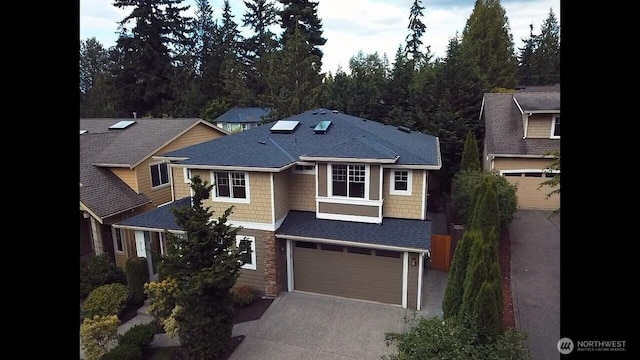 8910 125th Ln NE, Kirkland, WA 98033 - view of front of property featuring concrete driveway, a shingled roof, an attached garage, and stone siding