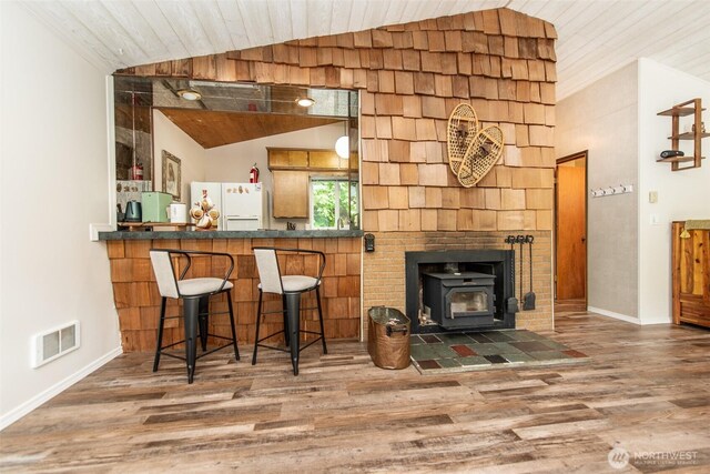 49 Sunny Point Ln, Port Angeles, WA 98363 - bar featuring freestanding refrigerator, vaulted ceiling, wood finished floors, a wood stove, and baseboards