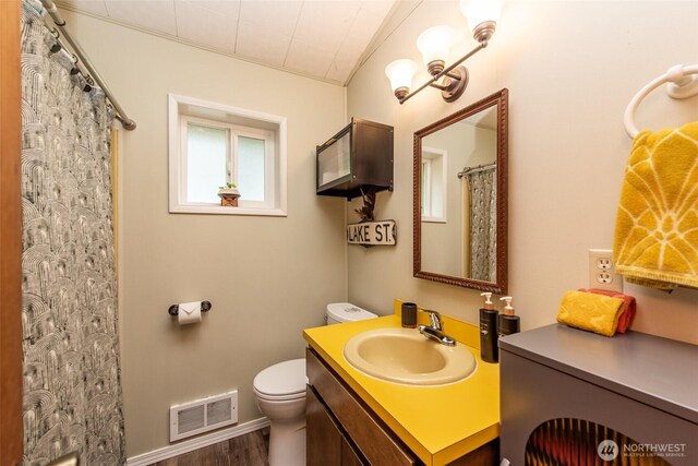 49 Sunny Point Ln, Port Angeles, WA 98363 - bathroom featuring vanity, toilet, wood finished floors, baseboards, and curtained shower
