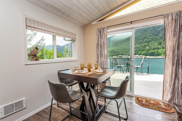49 Sunny Point Ln, Port Angeles, WA 98363 - dining space featuring lofted ceiling, wood finished floors, a wooded view, wooden ceiling, and baseboards