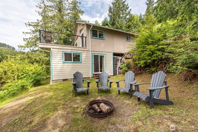 49 Sunny Point Ln, Port Angeles, WA 98363 - rear view of house with an outdoor fire pit, a balcony, and a lawn