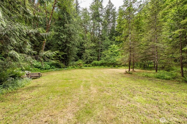 49 Sunny Point Ln, Port Angeles, WA 98363 - view of grassy yard with a wooded view