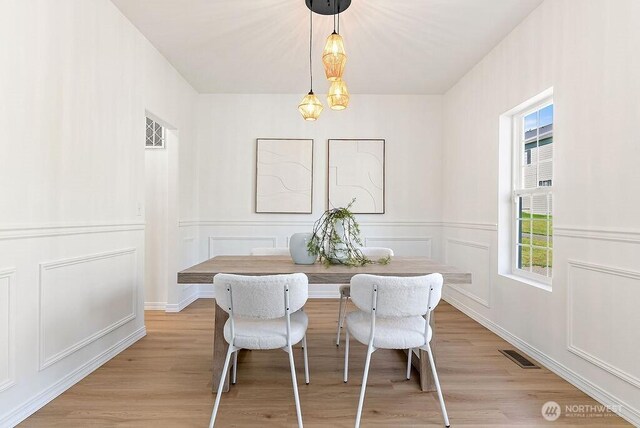 24212 112th Ave SE, Kent, WA 98030 - dining room with light wood-style floors, breakfast area, a decorative wall, and wainscoting