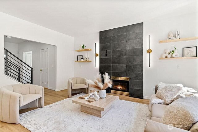 24212 112th Ave SE, Kent, WA 98030 - living room with stairway, light wood finished floors, a fireplace, and baseboards