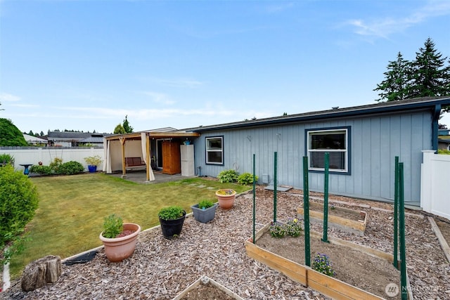 716 Dennis St SE Unit 93, Tumwater, WA 98501 - rear view of house with a vegetable garden, a fenced backyard, a patio, and board and batten siding