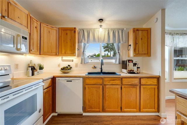 716 Dennis St SE Unit 93, Tumwater, WA 98501 - kitchen with white appliances, light countertops, dark wood finished floors, and brown cabinets