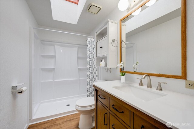 716 Dennis St SE Unit 93, Tumwater, WA 98501 - full bathroom with vanity, wood finished floors, a skylight, and a stall shower