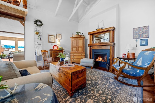 17257 Olympic View Rd NW, Silverdale, WA 98383 - living area featuring wood finished floors, high vaulted ceiling, a warm lit fireplace, and beam ceiling