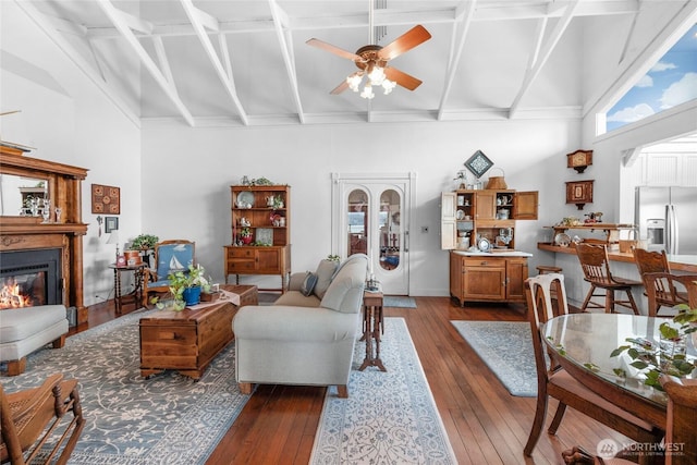 17257 Olympic View Rd NW, Silverdale, WA 98383 - living room featuring a high ceiling, a ceiling fan, dark wood-style flooring, a glass covered fireplace, and coffered ceiling