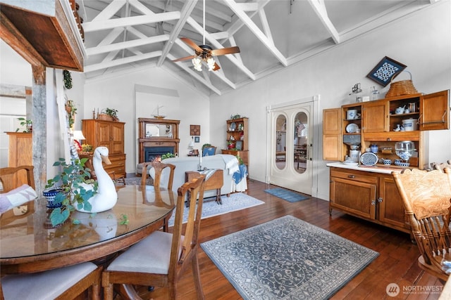 17257 Olympic View Rd NW, Silverdale, WA 98383 - dining area with a ceiling fan, a warm lit fireplace, and dark wood-style floors