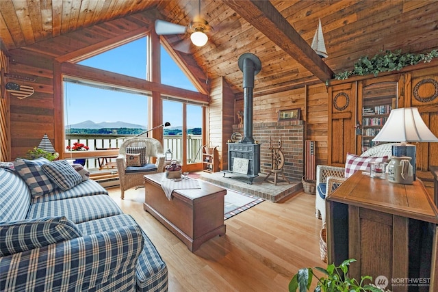 17257 Olympic View Rd NW, Silverdale, WA 98383 - living room with a mountain view, wooden walls, high vaulted ceiling, a wood stove, and light wood-style flooring