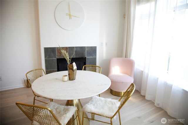 1900 Alaskan Way Unit 105, Seattle, WA 98101 - dining room with light wood finished floors, a fireplace, and baseboards