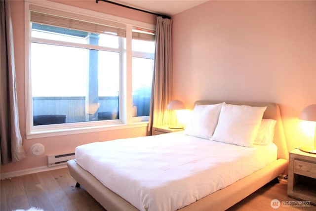 1900 Alaskan Way Unit 105, Seattle, WA 98101 - bedroom with baseboard heating and wood finished floors