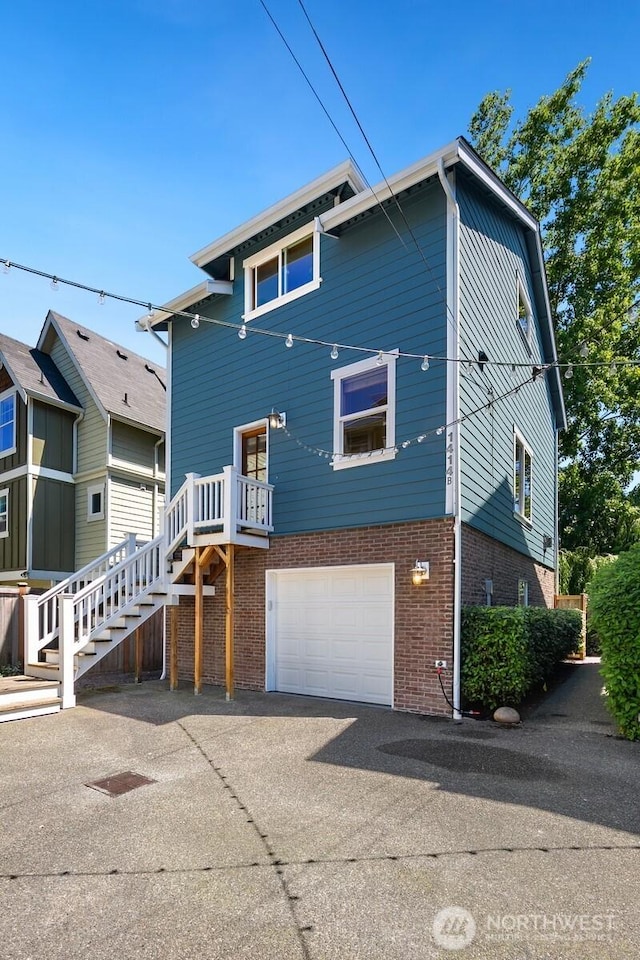 1414 25th Ave Unit B, Seattle, WA 98122 - view of front of property featuring brick siding, stairs, driveway, and a garage