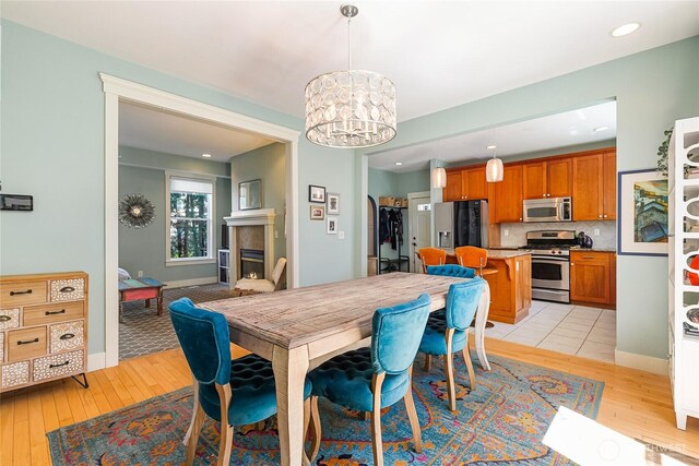 805 11th St, Bellingham, WA 98225 - dining area with light wood-style flooring, a chandelier, recessed lighting, a fireplace, and baseboards