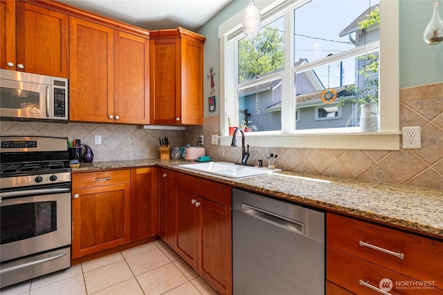 805 11th St, Bellingham, WA 98225 - kitchen with appliances with stainless steel finishes, a sink, brown cabinets, and light stone counters