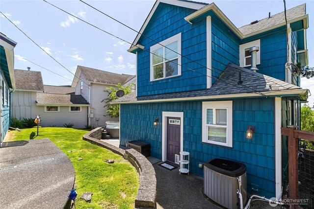 805 11th St, Bellingham, WA 98225 - view of front facade with cooling unit, a hot tub, a shingled roof, and a front lawn