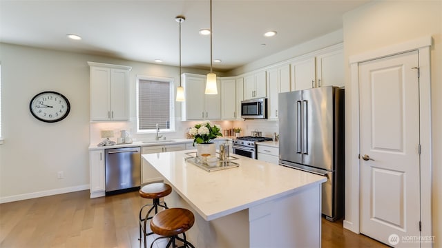 14528 35th Ave NE, Lake Forest Park, WA 98155 - kitchen with premium appliances, a breakfast bar area, white cabinetry, dark wood-style floors, and light countertops