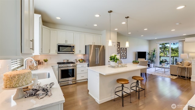 14528 35th Ave NE, Lake Forest Park, WA 98155 - kitchen with premium appliances, open floor plan, a kitchen island, wood finished floors, and a breakfast bar