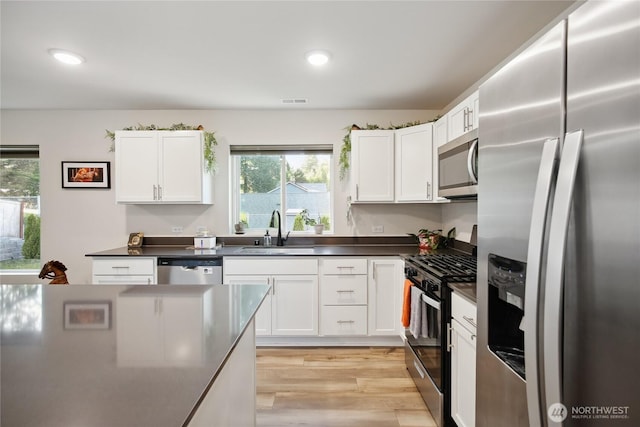 534 Gilbertson Ln SE, Olympia, WA 98501 - kitchen with stainless steel appliances, a sink, dark countertops, healthy amount of natural light, and recessed lighting