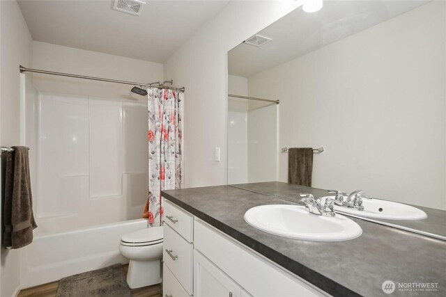 534 Gilbertson Ln SE, Olympia, WA 98501 - bathroom featuring vanity, toilet, shower / bathtub combination with curtain, and wood finished floors