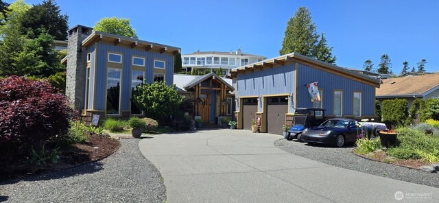 8145 Chehalis Rd, Blaine, WA 98230 - contemporary home featuring concrete driveway, an attached garage, and a chimney
